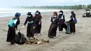 Sejumlah siswi membersihkan pantai dalam program Sekolah Pantai Indonesia (SPI) di pesisir Pantai Barat Pangandaran, Jawa Barat (23/11). Kegiatan Gerakan Cinta Laut oleh KKP menerapkan prinsip dari, oleh dan untuk siswa. (Liputan6.com/KKP)