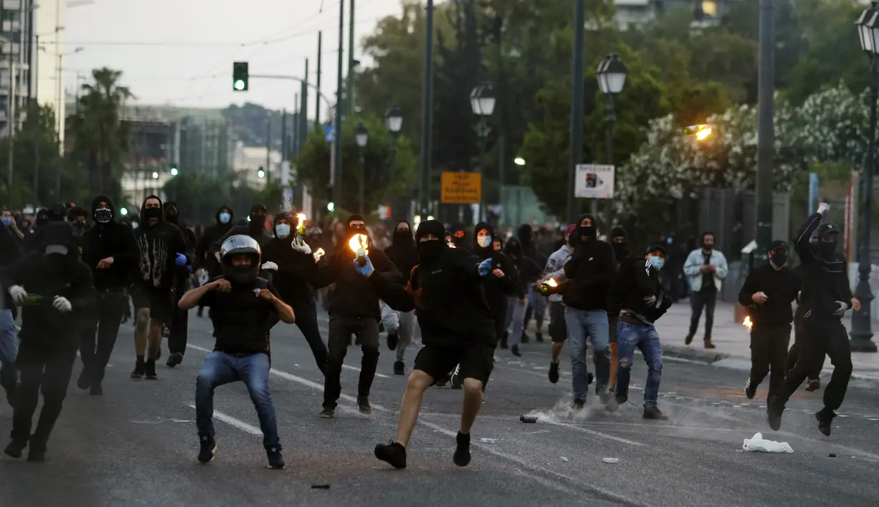 Demonstran melemparkan bom molotov ke arah polisi saat berunjuk rasa atas kematian George Floyd di luar Kedubes AS di Athena, Yunani, Rabu (3/6/2020). Kematian pria kulit hitam George Floyd saat ditangkap oleh polisi Amerika Serikat memicu kemarahan di sejumlah negara. (AP Photo/ Lefteris Pitarakis)