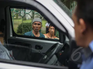 Seorang warga berkerumun melihat penemuan mayat dalam mobil di kawasan Taman Wiladatika, Jakarta Timur, Minggu (3/5/2015). Mayat pria yang diketahui bernama Sunoto (41) tersebut ditemukan oleh seorang penyapu jalanan. (Liputan6.com/Faizal Fanani)