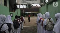Murid berbaris memasuki gedung sekolah saat pembelajaran tatap muka (PTM) terbatas di SDN Pisangan Baru 05 Pagi, Jakarta, Senin (8/11/2021). Orangtua dan guru diwajibkan disiplin mengedukasi protokol kesehatan secara lisan maupun melalui media sosial. (merdeka com/Iqbal S. Nugroho)