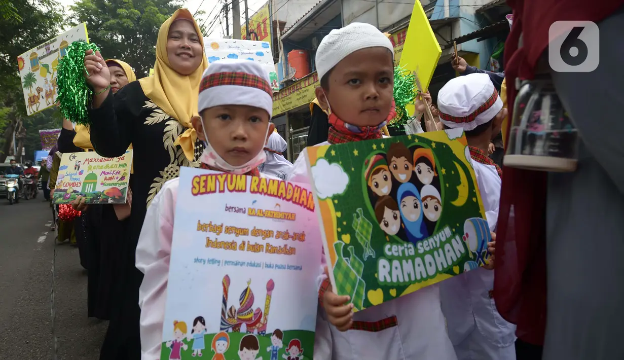 Sejumlah murid TK Islam berjalan bersama sambil membawa poster di Jalan Raya Radjiman Widyo Ningrat, Jakarta, Sabtu (26/3/2022). Pawai menyambut datangnya bulan suci Ramadan 1443 Hijriah ini diikuti puluhan murid TK Islam dari berbagai sekolah. (merdeka.com/Imam Buhori)