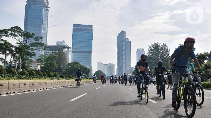 Warga mengendarai sepeda saat kegiatan Car Free Day (CFD) di Kawasan Sudirman, Jakarta, Minggu (21/6/2020). Pada CFD pertama di masa PSBB Transisi, warga Ibu Kota terlihat lebih memilih bersepeda sebagai sarana olahraga dengan tetap menerapkan protokol kesehatan Covid-19. (merdeka.com/Iqbal Nugroho)