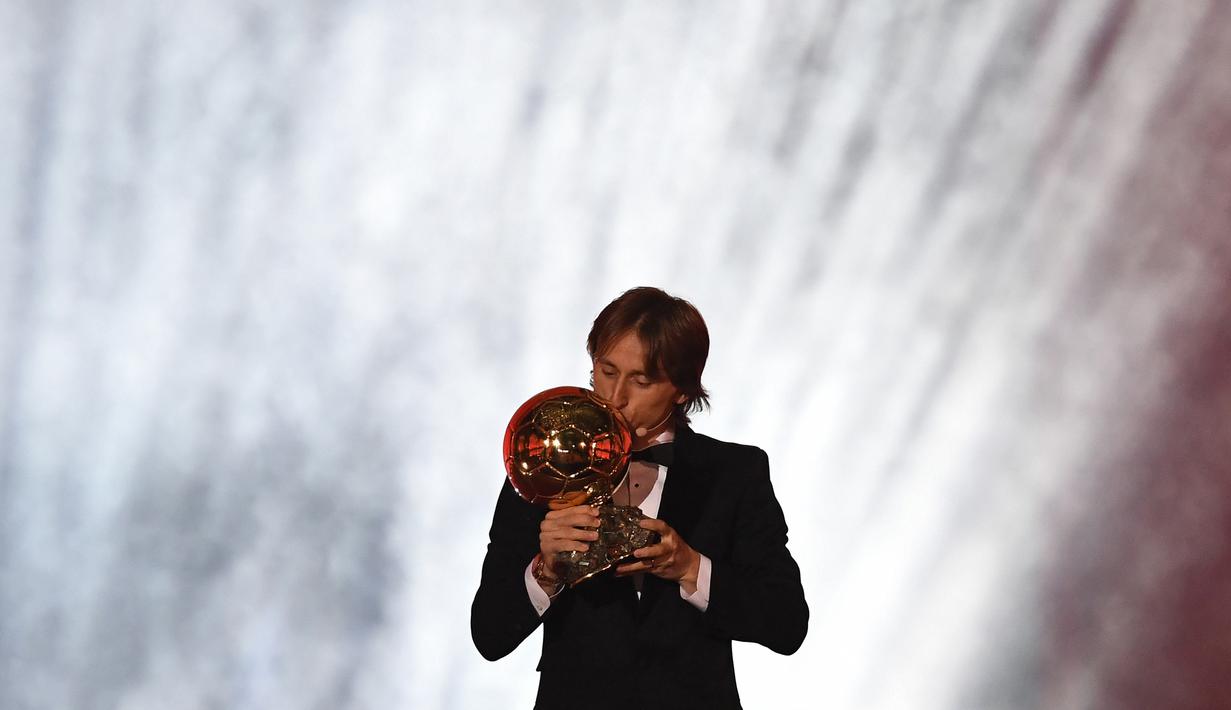 Gelandang Real Madrid asal Kroasia, Luka Modric, mencium trofi saat malam penghargaan Ballon d'Or di Paris, Senin (3/12). Dirinya berhasil meraih gelar Ballon d'Or. (AFP/Franck Fife)