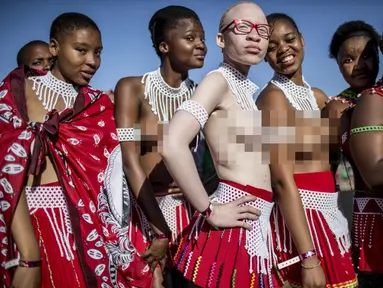 Seorang gadis albino Afrika Selatan berpose dengan gadis lain, telanjang dada dalam upacara Reed Dance, Afsel (5/9/2014) (AFP PHOTO / MARCO LONGARI)