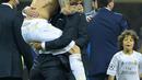 Sergio Ramos melompat sambil memeluk Zidane saat meraih trofi Liga Champions di San Siro Stadium, Milan, (28/5/2016). Zinedine mundur sebagai pelatih Madrid 31 Mei 2018. (AFP/Olivier Morin)
