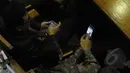 Saat rapat Paripurna sejumlah anggota dewan sibuk dengan ponselnya. Seorang anggota dewan memperlihatkan sesuatu di ponsel kepada rekannya, Jakarta (09/02/2015). (Liputan6.com/Andrian M Tunay)