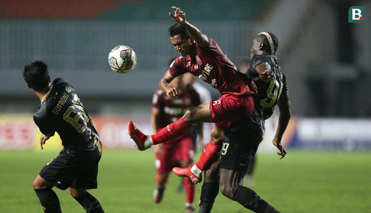 Pemain Persis Solo, Muhammad Abduh Lestaluhu (tengah) berebut bola dengan pemain Martapura Dewa United, Herman Dzumafo (kanan) dalam laga semifinal Liga 2 2021 di Stadion Pakansari, Bogor, Senin (27/12/2021). (Bola.com/Bagaskara Lazuardi)