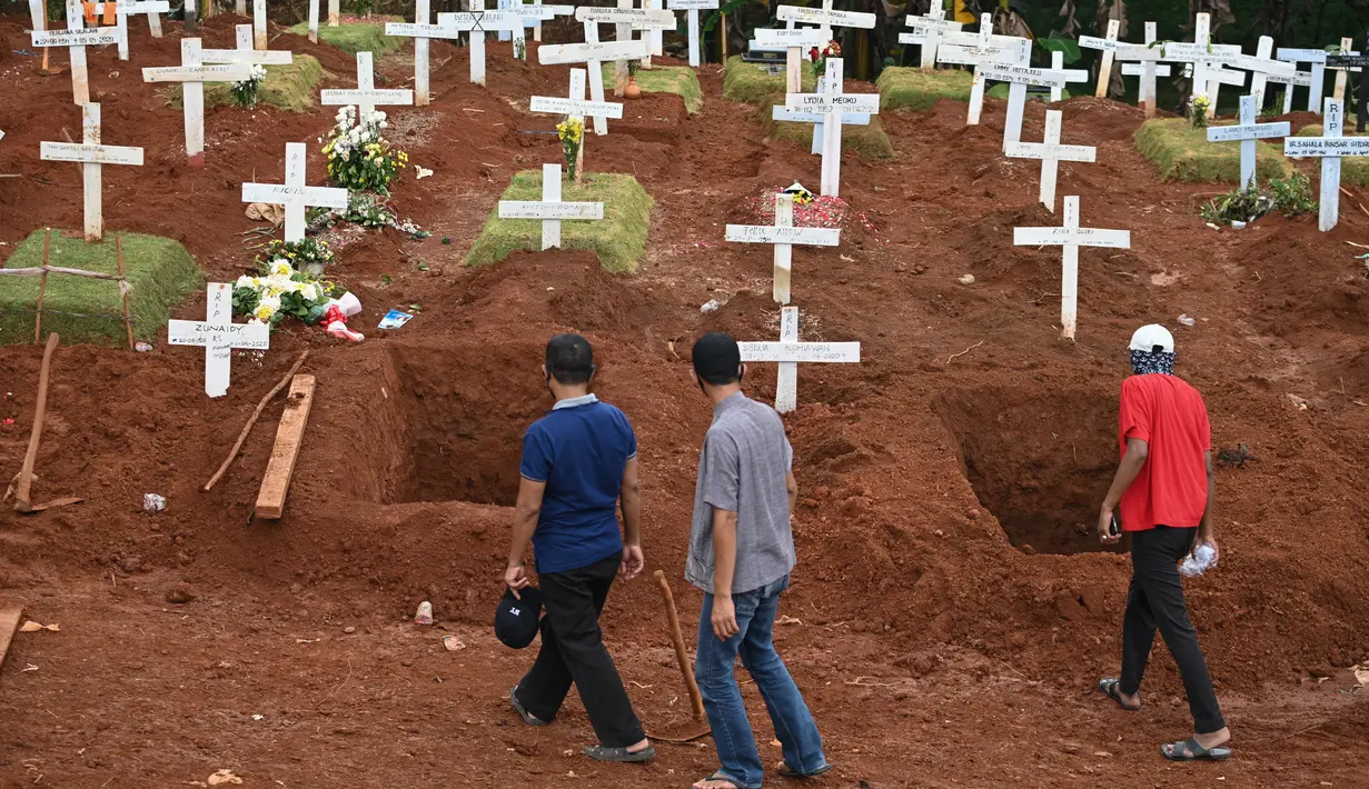 Keluarga korban yang meninggal karena virus corona COVID-19 melewati sejumlah makam di sebuah pemakaman di Jakarta, Rabu (15/4/2020). Hingga sore ini, jumlah kasus COVID-19 di Indonesia sebanyak 5.136 positif, 446 sembuh, dan 469 meninggal dunia. (Bay ISMOYO/AFP)