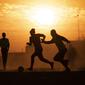 Orang-orang bermain sepak bola di lapangan berdebu di Soweto, Afrika Selatan, 19 Agustus 2020. Presiden Afrika Selatan Cyril Ramaphosa mengumumkan bahwa seluruh negara akan melakukan lockdown level 2 mulai hari Selasa. (AP Photo/ Themba Hadebe)