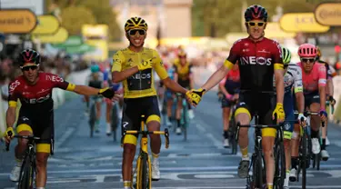 Pebalap Kolombia Egan Bernal (tengah) berpegangan tangan dengan Geraint Thomas setelah memenangkan balap sepeda Tour de France 2019, Paris, Prancis, Minggu (28/7/2019 ). Egan Bernal menjuarai Tour de France 2019 setelah menempuh perjalanan lebih dari 3,409 km. (AP photo/Michel Euler)