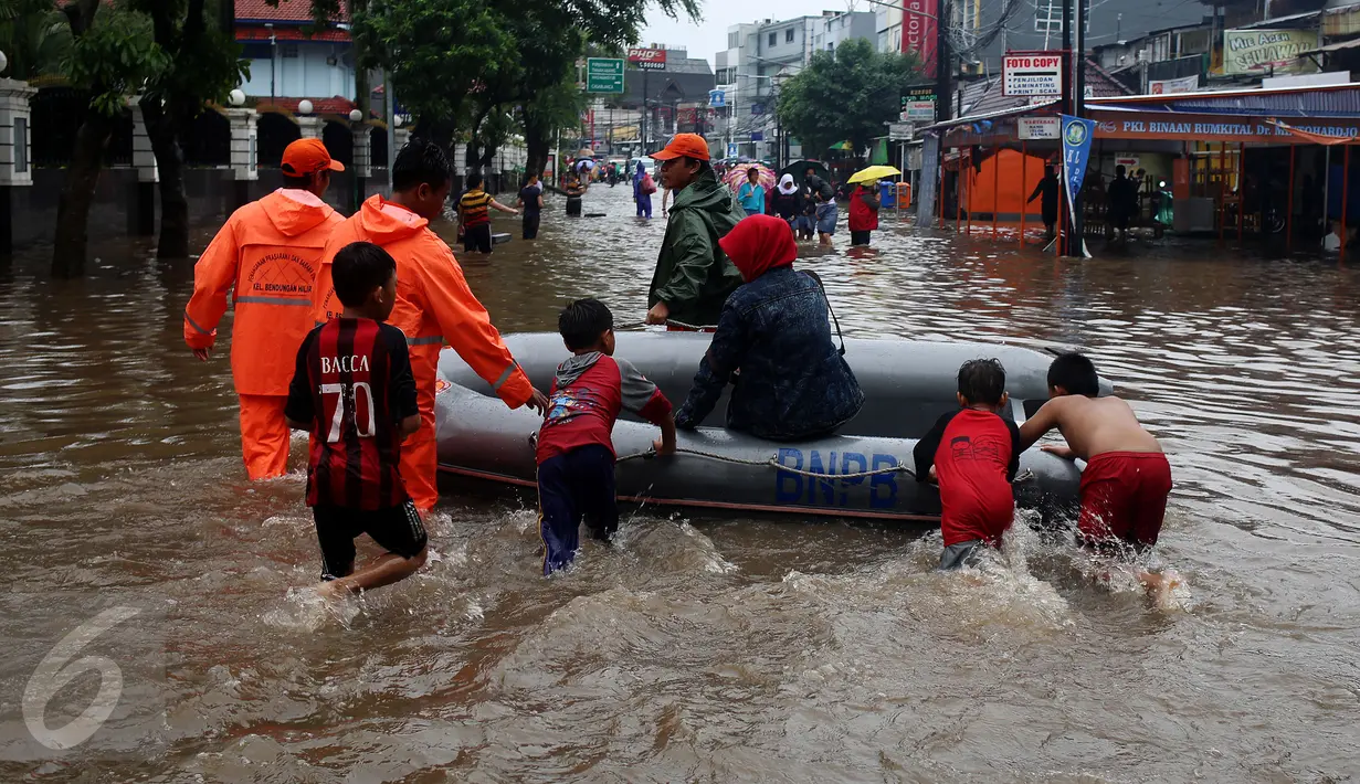 Sejumlah anak bersama petugas membantu warga melewati banjir yang merendam kawasan Benhil RT 03 RW 05, Jakarta Pusat, Selasa (21/1). Hujan deras yang mengguyur sejak Selasa dinihari mengakibatkan kawasan itu mengalami banjir. (Liputan6.com/Johan Tallo)