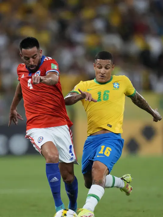 Bek Brasil, Guilherme Arana berebut bola dengan bek Chile, Mauricio Isla selama pertandingan kualifikasi Piala Dunia 2022 zona CONMEBOL di stadion Maracana di Rio de Janeiro, Brasil, Jumat (25/3/2022). Brasil menang atas Chile 4-0. (AP Photo/Silvia Izquierdo)
