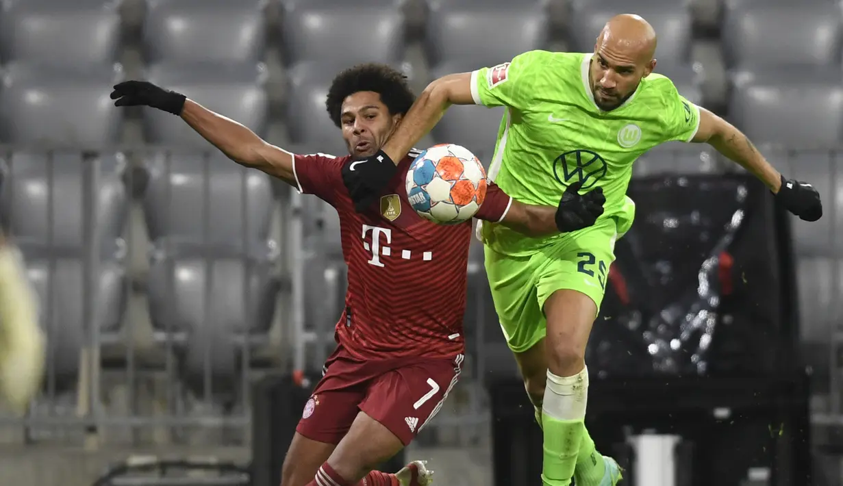 Bek VfL Wolfsburg John Brooks (kanan) berebut bola dengan gelandang Bayern Munchen Serge Gnabry pada pekan ke-17 Liga Jerman di Allianz Arena Sabtu (18/12/2021) dinihari WIB. Bayern mencukur Wolfsburg dengan skor 4-0. (AP Photo/Andreas Schaad)