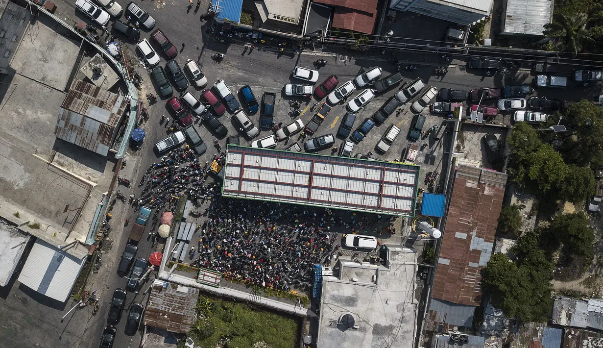 Kendaraan menunggu dalam antrean di salah satu dari beberapa SPBU terbuka selama kekurangan bahan bakar nasional di Port-au-Prince, Haiti, Minggu (31/10/2021). SPBU mengalami kekeringan akibat geng-geng memblokir pintu masuk ke pelabuhan yang menyimpan bahan bakar. (AP Photo/Matias Delacroix)