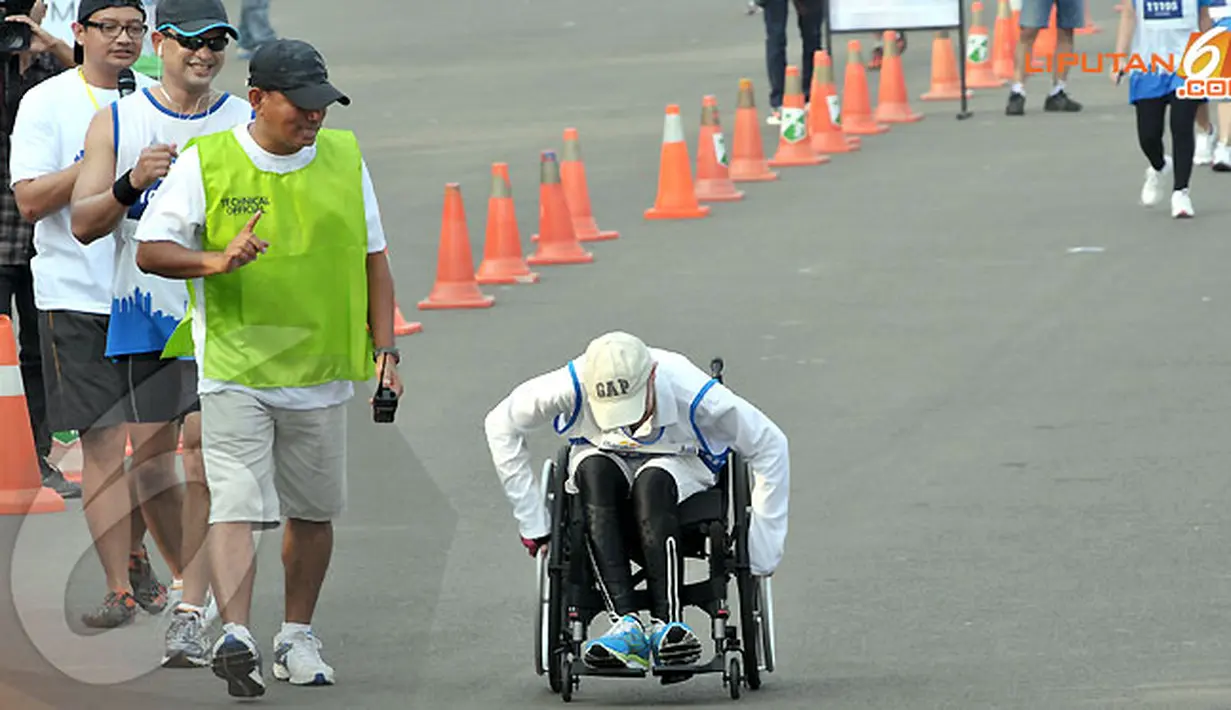 Raechana Syafei (45 tahun) memacu kursi roda dan sampai di garis finish dengan waktu 2 jam 15 menit dengan jarak lari 10 km. (Liputan6.com/Andrian M. Tunay)