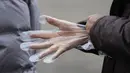 Pengunjung memakai sarung tangan plastik saat antre untuk tes corona di klinik skrining sementara di Seoul, Korea Selatan, Jumat (10/12/2021). Otoritas kesehatan Korea Selatan melaporkan lebih dari 7.000 kasus COVID-19 baru untuk ketiga hari berturut-turut pada hari Jumat ini. (AP Photo/Lee Jin-man)
