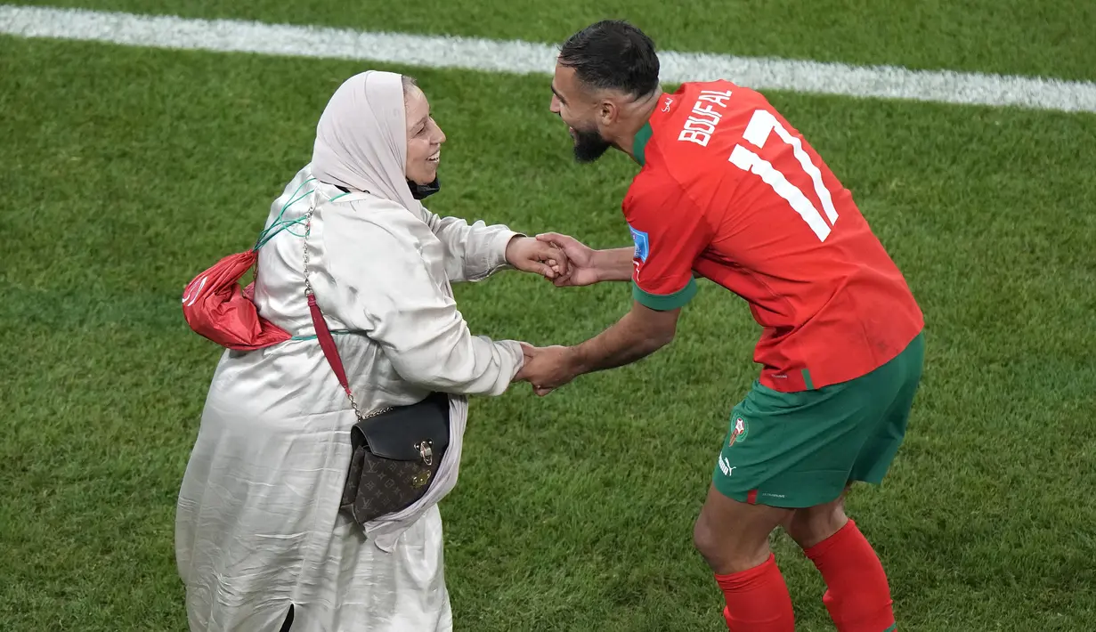 Pemain Maroko, Sofiane Boufal (kanan) merayakan kemenangan bersama ibunya setelah timnya berhasil mengalahkan Portugal pada laga perempat final Piala Dunia 2022 yang berlangsung di Al Thumama Stadium, Qatar, 10 Desember 2022. (AP Photo/Luca Bruno)