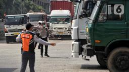 Puluhan petugas gabungan dari unsur Polisi Lalu Lintas dan Dinas Perhubungan Daerah Khusus Jakarta melakukan pengaturan lalu lintas untuk mengurai kemacetan panjang di sekitar Pelabuhan Tanjung Priok, Jakarta, Jumat 18 April 2025. (Liputan6.com/Angga Yuniar)