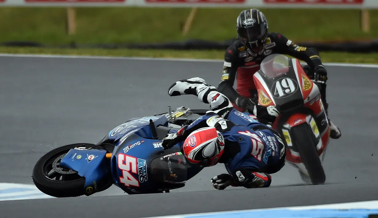 Pebalap Italtrans Racing, Mattia Pasini terjatuh dekat pebalap AGR team, Axel Pons pada sesi pertama pratice Moto 2 Australian Grand Prix di Phillip Island (22/10/2016). (AFP/Saeed Khan)