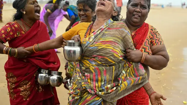 Seorang wanita menangis saat melakukan ritual selama upacara peringatan untuk para korban tsunami Samudra Hindia 2004 di Pantai Pattinapakkam di Chennai, India. [R Satish Babu/AFP]