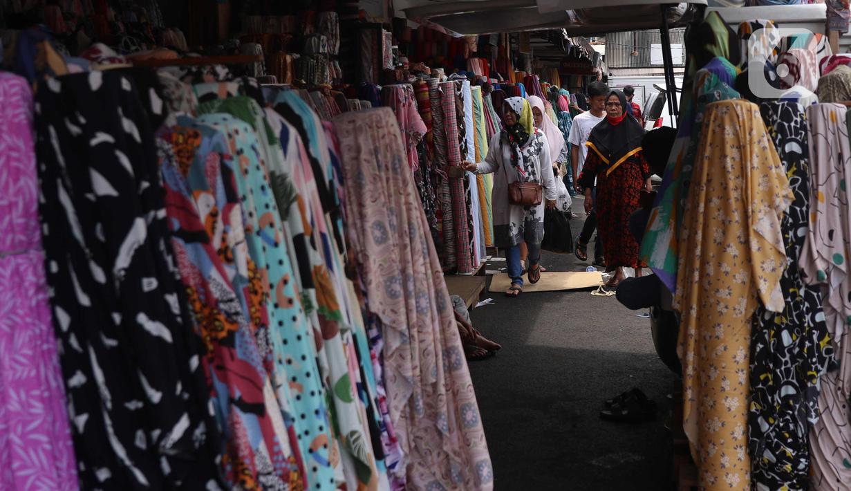 Calon pembeli melihat-lihat kain di Pasar Cipadu, Tangerang, Selasa (2/3/2021). Pandemi Covid-19 membuat industri tekstil dan pakaian jadi mengalami pertumbuhan negatif 8, 8 persen sepanjang 2020 dengan kinerja ekspor yang berkontraksi 17 persen. (Liputan6.com/Angga Yuniar)