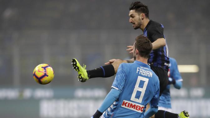 Gelandang Inter Milan, Matteo Politano, berebut bola dengan pemain Napoli, Fabian Ruiz, pada laga Serie A di Stadion San Siro, Rabu (26/12). Inter Milan menang 1-0 atas Napoli. (AP/Luca Bruno)