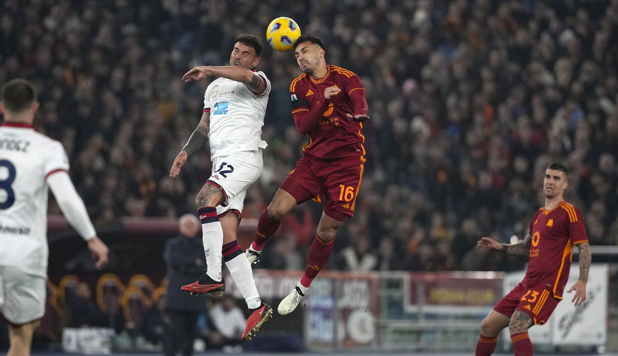 Pemain AS Roma, Leandro Paredes (kanan) berduel udara dengan pemain Cagliari, Andrea Petagna pada laga lanjutan Liga Italia 2023/2024 di Olympic Stadium, Roma, Italia, Selasa (06/02/2024) dini hari WIB. (AP Photo/Andrew Medichini)