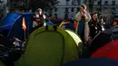 Seorang pria memainkan gitar saat aktivis iklim berkemah di Whitehall, London, Inggris, Selasa (8/10/2019). Protes global oleh gerakan Pemberontakan Kepunahan menuntut tindakan yang lebih mendesak untuk melawan perubahan iklim. (AP Photo/Alastair Grant) (AP Photo/Hibah Alastair)