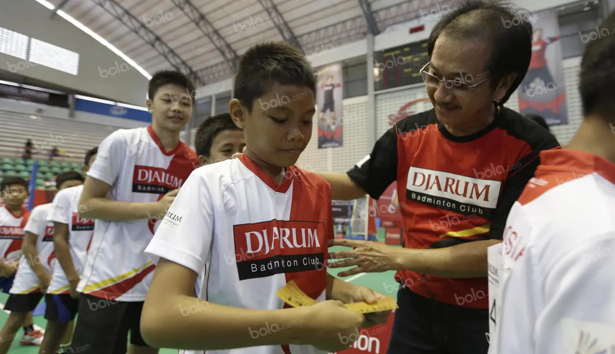 Anggota tim pemandu bakat, Eddy Prayitno, memberikan super tiket tambahan kepada seorang peserta Audisi Umum Beasiswa Bulutangkis PB Djarum di GOR Sritex, Solo, Senin (11/4/2016). (Bola.com/Arief Bagus)