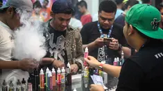 Pecinta Vape atau rokok elektrik sedang mencoba keunggulan alat dan rasa liquid di stand Vape Fair 2016 di Ecovention Hall Ancol, Jakarta, Minggu (27/11). (Liputan6.com/Faizal Fanani)