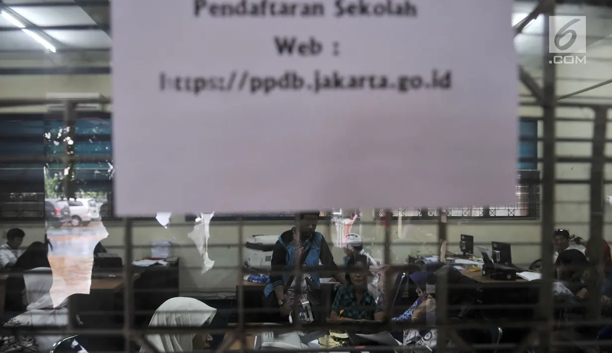 Suasana saat orangtua calon siswa baru menunggu antrean mengambil nomor token PPDB di SMPN 92, Jakarta, Senin (25/6). PPDB tingkat SMP, SMA, dan SMK yang digelar serentak mulai hari ini. (Merdeka.com/Iqbal S Nugroho)