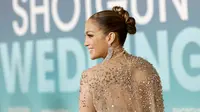 Aktris Jennifer Lopez berpose di pemutaran perdana film "Shotgun Wedding" di Los Angeles di TCL Chinese Theater di Hollywood, California (18/1/2023). Lapisan smoky eye shadow yang berani menambah kesan dramatis, sedangkan kilau segar dari lip gloss menambahkan sentuhan feminin. Dia mengguncang anting-anting perak yang menjuntai di atas bahunya dan membawa kopling velour kuning berbentuk kotak. (Emma McIntyre/Getty Images/AFP)