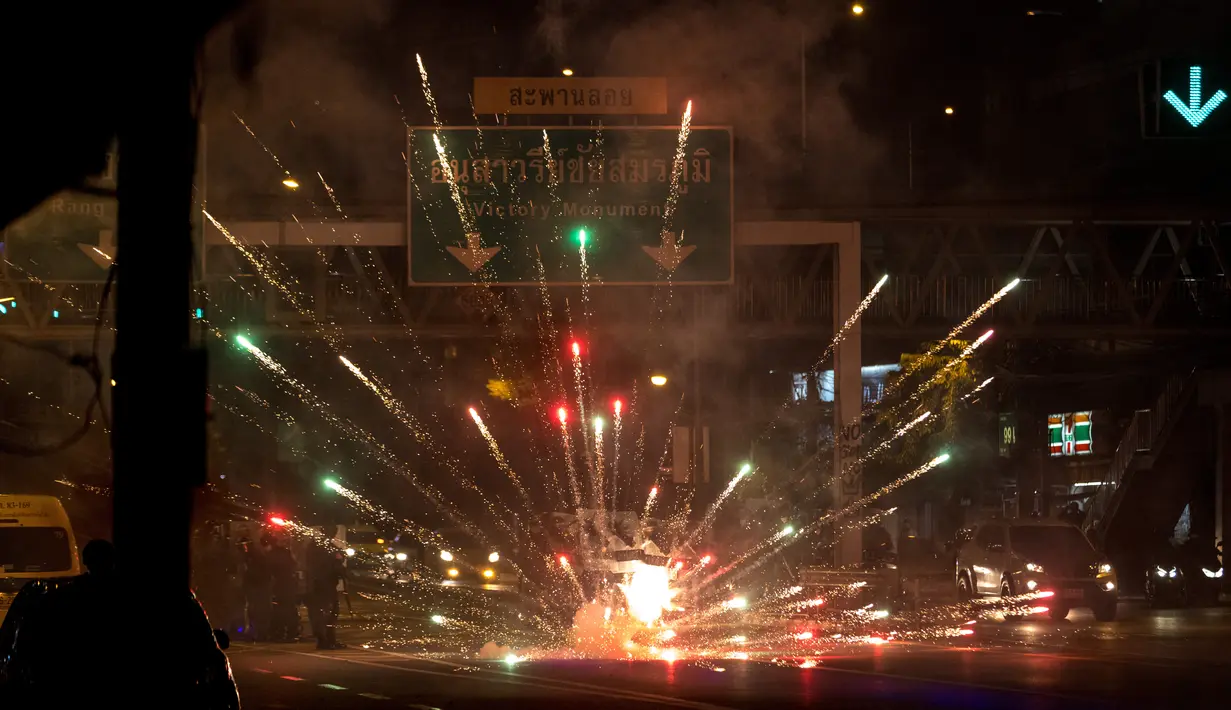 Petasan yang dilemparkan oleh pengunjuk rasa meledak di depan barisan polisi selama demonstrasi di Bangkok, Thailand, Minggu (6/9/2021). Aksi unjuk rasa yang menyuarakan pengunduran diri Perdana Menteri Thailand, Prayut Chan-O-Cha makin mencekam hingga malam hari. (AFP/Jack Taylor)