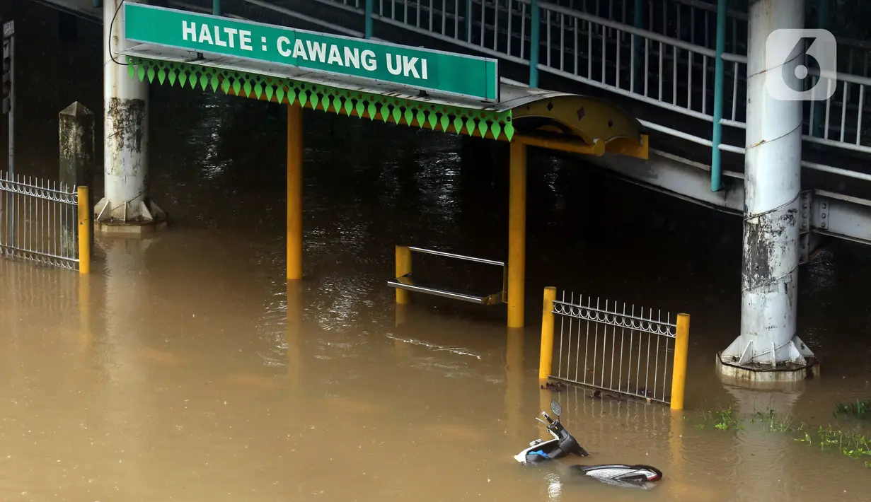 Sebuah motor tergeletak di Jalan Di Panjaitan dekat Halte Transjakarta Cawang Soetoyo yang tergenang banjir, Jakarta, Rabu (1/1/2020). Hujan yang mengguyur Jakarta sejak Selasa sore (31/12/2019) mengakibatkan banjir di sejumlah titik di Jakarta. (Liputan6.com/Helmi Fithriansyah)
