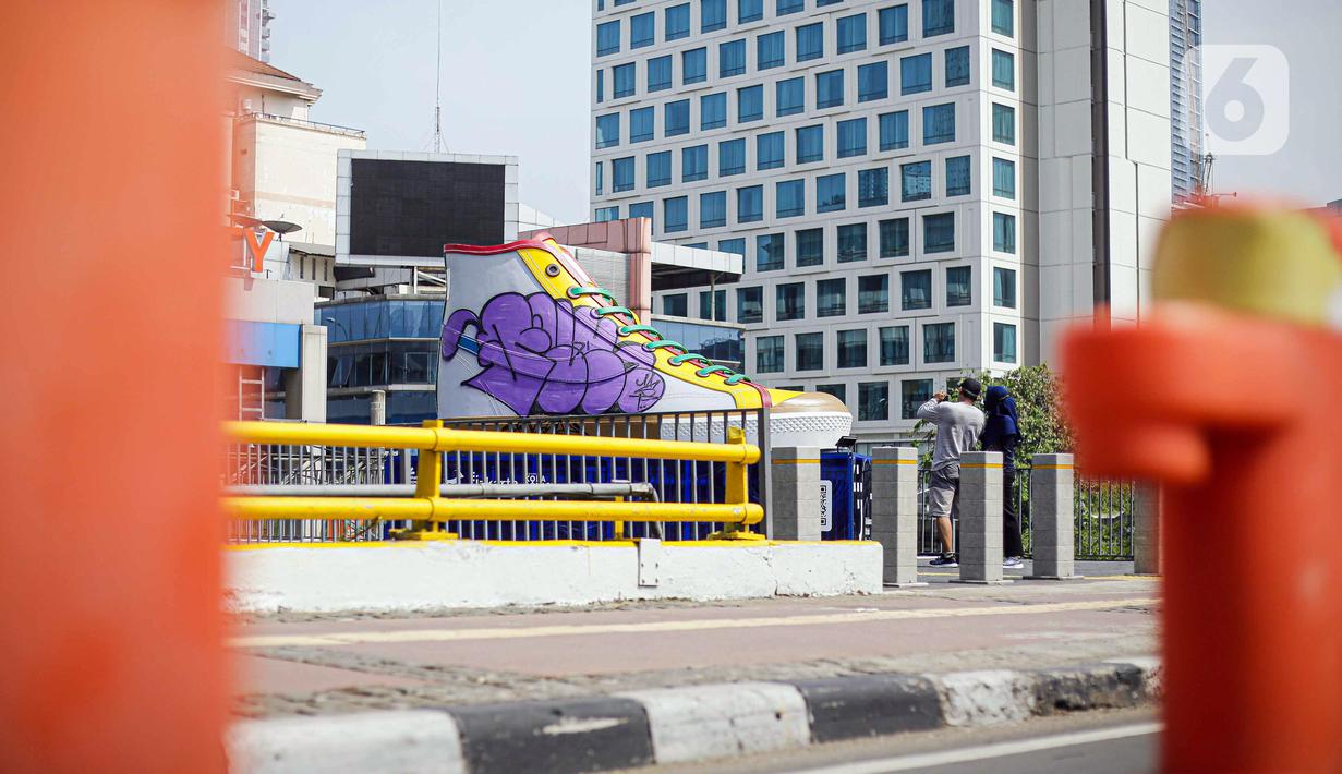 Suasana di sekitar Tugu Sepatu, Sudirman, Jakarta, Minggu (19/9/2021). Tugu Sepatu menjadi sasaran pencoretan dengan semprotan aerosol oleh orang tak dikenal sehari usai diresmikan pada 17 September 2021. (Liputan6.com/Faizal Fanani)