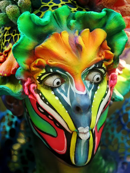 Ekspresi model dengan cat ultraviolet di wajahnya saat mengikuti Festival Bodypainting Dunia 2015 di Poertschach, Austria, (3/7/2015). Festival ini menampilkan beragam motif lukisan unik hasil karya para seniman terkemuka dunia. (Reuters/Heinz-Peter Bade)
