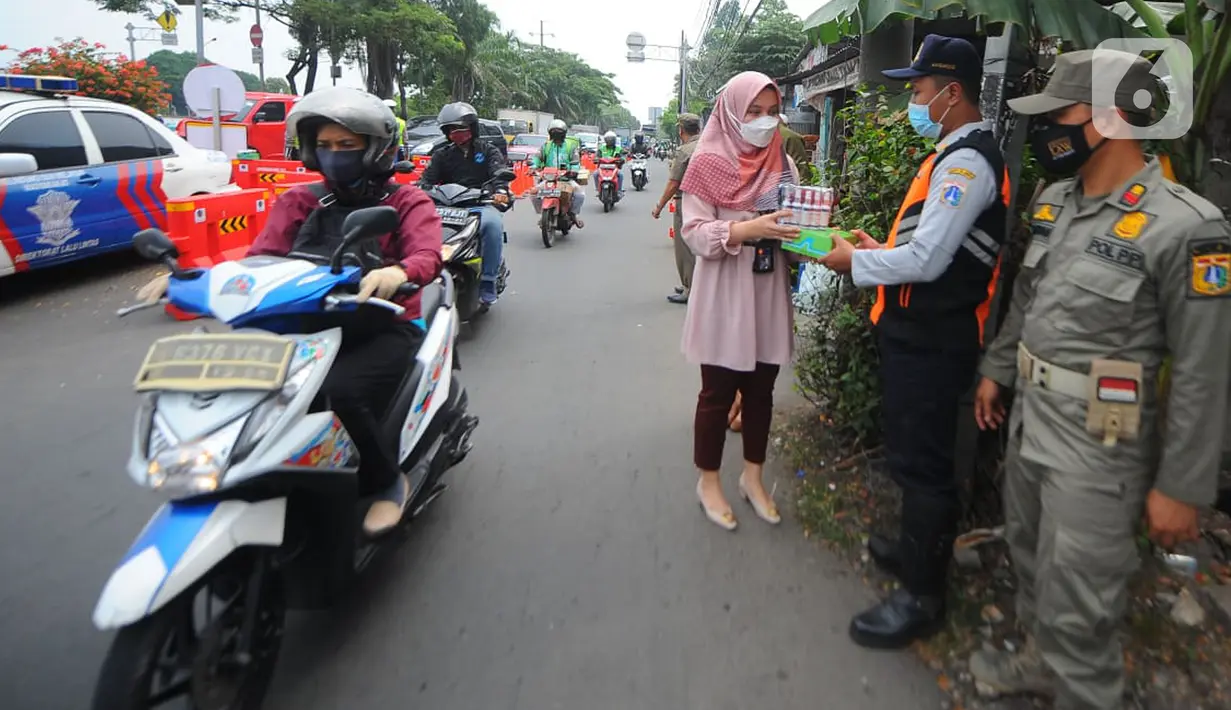 Pegawai PT Bank Tabungan Negara (BTN) membagikan makanan dan hand sanitizer kepada petugas yang menjaga area penyekatan di kawasan Samsat Daan Mogot, Jakarta, Kamis (22/07/2021). Bantuan BTN Peduli pada PPKM Darurat membantu petugas menekan dan meminimalisasi penularan Covid-19. (Liputan6.com) 