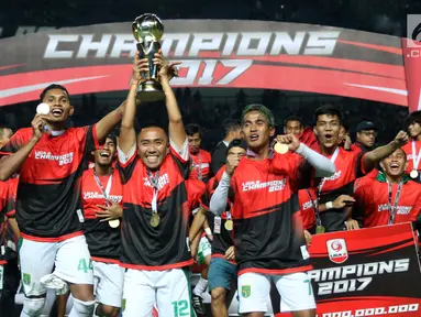 Kapten tim Persebaya, Rendi Irwan Saputra (tengah) mengangkat piala usai menumbangkan PSMS Medan di Final Liga 2 Indonesia di Stadion GBLA, Bandung, Selasa (28/11). Persebaya unggul 3-2 atas PSMS Medan. (Liputan6.com/Helmi Fithriansyah)
