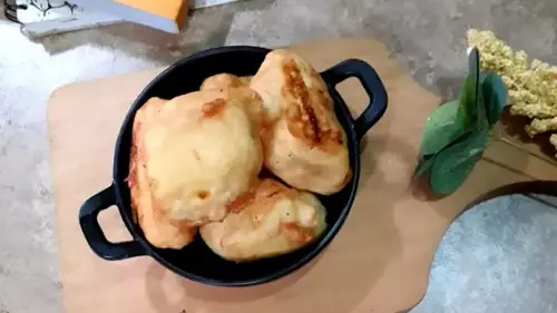 Pisang goreng durian dengan isian durian creamy, disajikan hangat dengan taburan keju parut dan susu kental manis