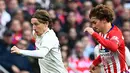 Striker Atletico Madrid, Antoine Griezmann berusaha merebut bola yang dibawa gelandang Real Madrid, Luka Modric selama pertandingan Liga Spanyol di di stadion Wanda Metropolitano di Madrid (9/2/2019). (AFP Photo/Gabriel Bouys)