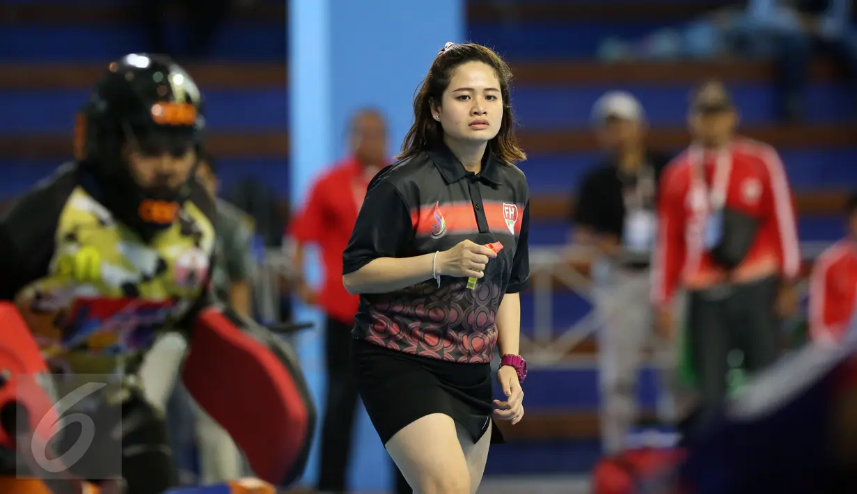 Wasit Ornpimol Kittiteerasopon (tengah) saat mengawasi dan memimpin laga final hoki putri PON XIX Jabar antara DKI Jakarta melawan Papua di Gymnasium UPI, Bandung, Senin (19/9). DKI Jakarta unggul 4-2 atas Papua. (Liputan6.com/Helmi Fithriansyah)