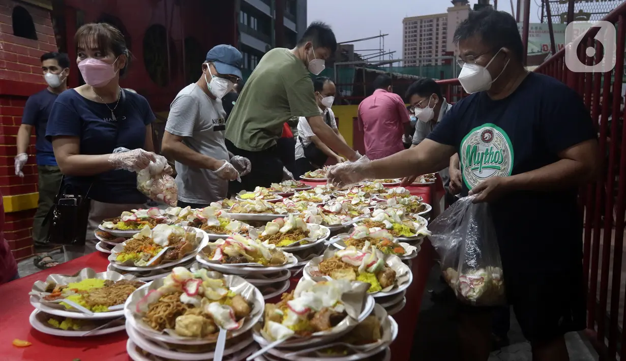 Warga menyiapkan menu berbuka puasa di Vihara Dharma Bhakti, Petak Sembilan, Jakarta, Kamis (7/4/2022). Yayasan Vihara Dharma Bhakti menyediakan sekitar 200 porsi menu berbuka puasa bagi warga sekitar untuk lebih mempererat persaudaraan umat beragama. (Liputan6.com/Helmi Fithriansyah)