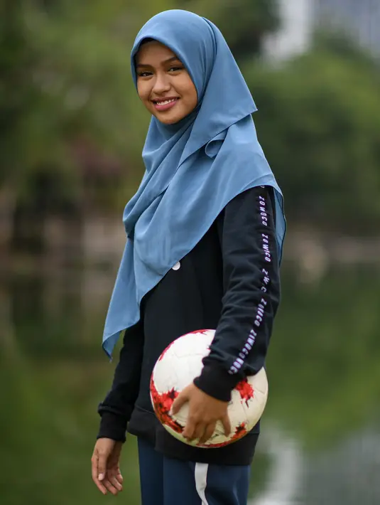 Freestyler sepak bola, Qhouirunnisa Endang Wahyudi berpose sebelum menunjukkan keterampilannya mengolah bola di sebuah taman di Klang, Kuala Lumpur, (11/7). (AFP Photo/Mohd Rasfan)