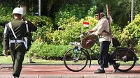 Seorang Veteran Surabaya, menuntun sepeda kuno serta memakai kostum pejuang 45, disapa oleh anggota Polisi Militer TNI AD, saat upacara Hari Pahlawan di Grahadi Surabaya. (Antara)