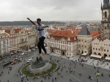 Atlet menyeimbangkan tubuhnya saat berjalan di atas tali yang membentang di Old Town Square, Praha, Republik Ceko, (25/9). Pertunjukan tersebut merupakan bagian kampanye dukungan bagi orang-orang yang hidup dengan diabetes. (AP Photo/Petr David Josek)