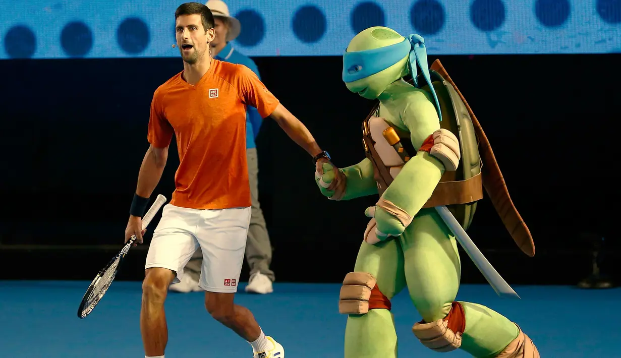 Petenis Serbia, Novak Djokovic menggandeng satu karakter kura - kura ninja di Melbourne Park, Australia, (16/1).  Acara ini juga sebagai kampanye penyelenggaraan Turrnamen  tenis Australia Terbuka yang dimulai 18 januari 2016. (REUTERS / Issei Kato)