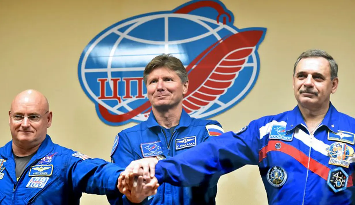 Astronot Scott Kelly (AS), Gennady Padalka dan Mikhail Kornienko (kiri ke kanan) bersalaman usai jumpa pers di Baikonur Kosmodrom, 26 Maret 2015. Ketiganya dijadwalkan lepas landas menuju ISS dari Baikonur, 28 Maret 2015. (AFP PHOTO/Kirill KUDRYAVTSEV)