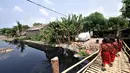 Anak sekolah melintas di pinggir Kali Pisang Batu yang dipenuhi sampah, Tarumajaya, Bekasi, Jawa Barat, Rabu (9/1). Warga tetap beraktivitas meski bau tak sedap menghantui mereka akibat tumpukan sampah di kali tersebut. (Merdeka.com/Iqbal S. Nugroho)
