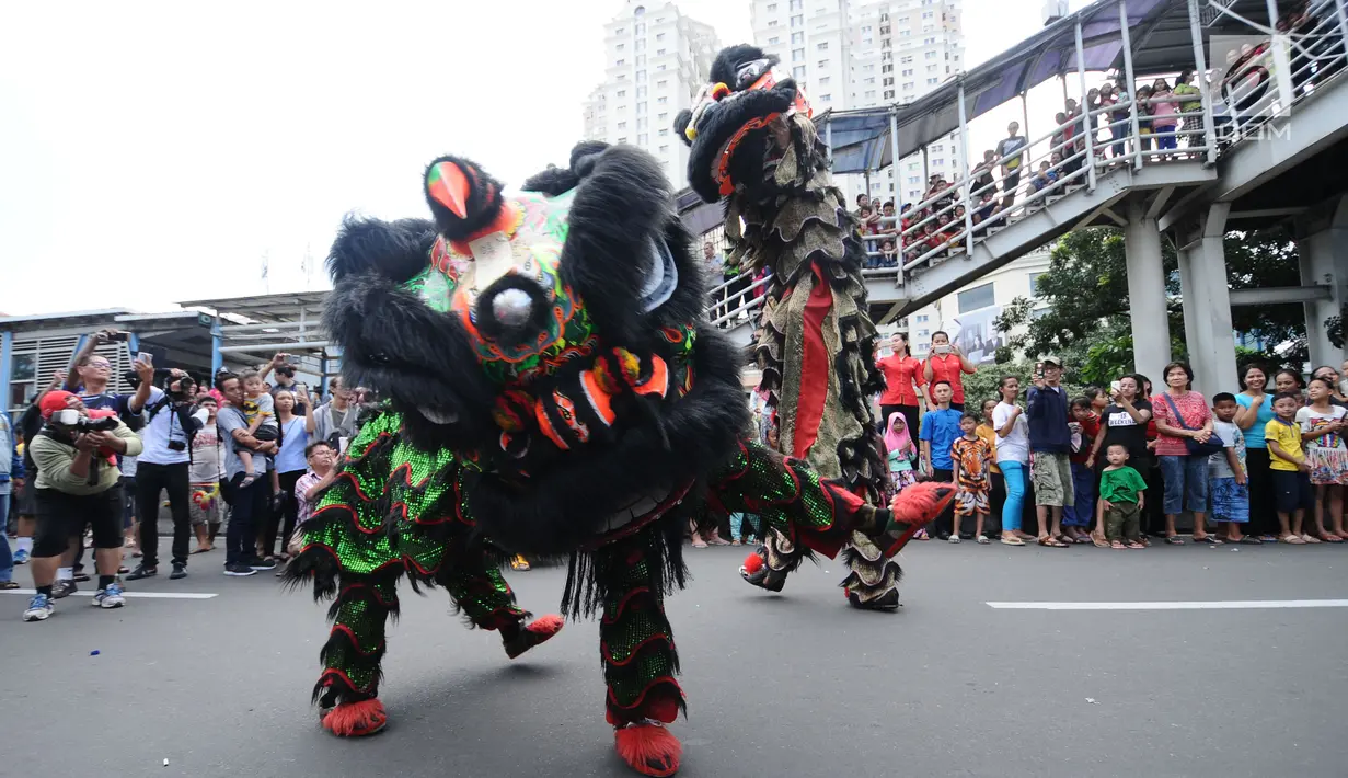 Atraksi barongsai dan liong diantara kerumunan warga di Jalan Gajah Mada, Jakarta, Minggu (4/3). Beragam atraksi budaya yang ada di Indonesia ditampilkan dalam karnaval perayaan Cap Go Meh 2018 di kawasan Glodok Jakarta. (Liputan6.com/Helmi Fithriansyah)