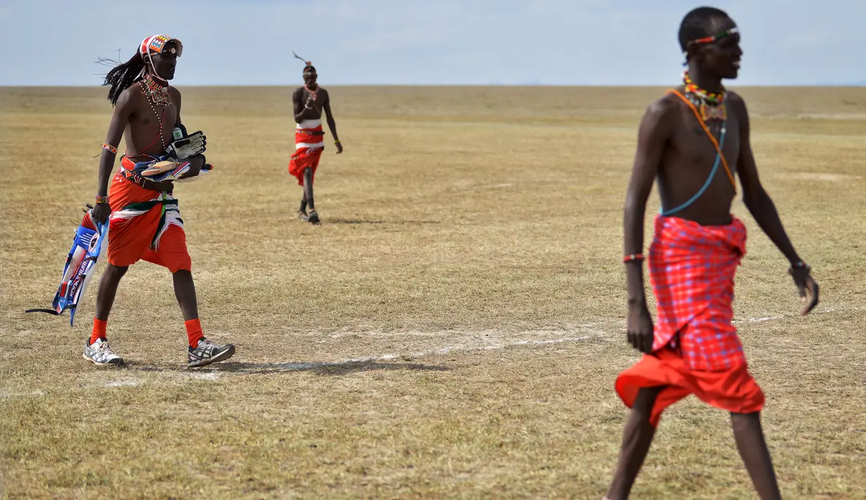 Suku Maasai membawa peralatannya untuk mengikuti pertandingan amal kriket di kaki Gunung Kenya (18/6). Mereka juga berusaha menggalang dana untuk penelitian yang berguna untuk menyelamatkan spesies badak putih. (AFP Phoo/Tony Karumba)